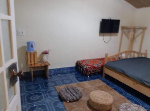 a bedroom with a bed and a table and a tv at Forelsket 2 in Da Lat