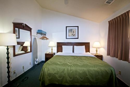 una camera d'albergo con un letto e due lampade di Quality Inn Yosemite Valley Gateway a Mariposa