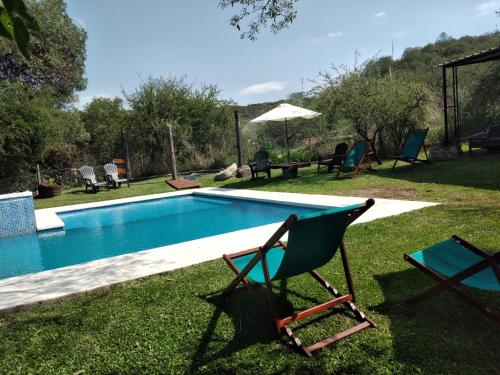 a chair sitting next to a swimming pool at Cabañas La Joaquina in Río Ceballos