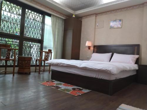 a bedroom with a bed and a large window at Coffee Street Homestay in Gukeng