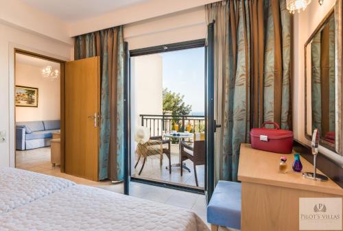 a bedroom with a king sized bed and a balcony at Pilot's Villas Luxury Suites in Hersonissos