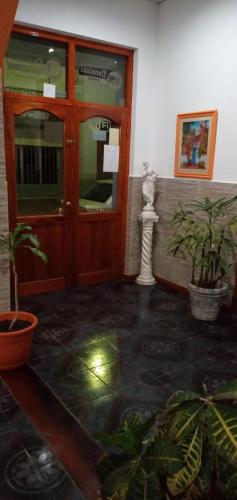 a lobby with a wooden door and potted plants at Dennisse Hotel in Victoria