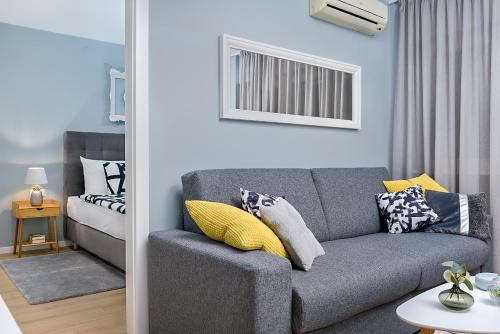 sala de estar con sofá gris y cama en Charming Place near Centre with GARAGE parking, en Zagreb