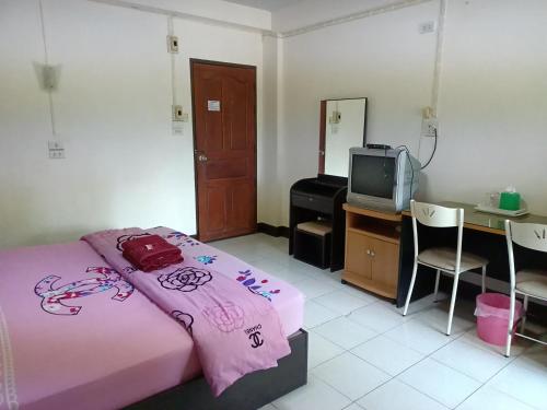 a bedroom with a pink bed and a television at ทองธิดาอพาร์ทเม้นท์ in Phitsanulok