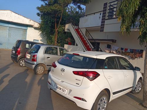 a white car parked in front of a building at Krishna Homestay Hampi in Hampi