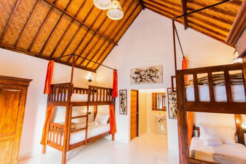 a room with two bunk beds and a bathroom at Camar Cottage & Hostel in Nusa Penida