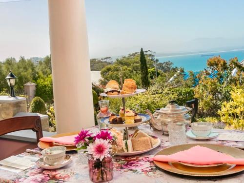 uma mesa com comida e vista para o oceano em Betty's Boutique Hotel em Mossel Bay