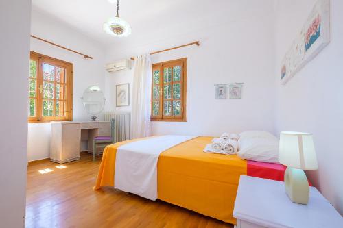 a white bedroom with a bed and a desk at Messinia - George Cottage in Kalamata