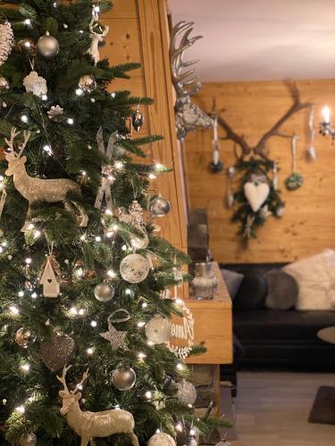 a christmas tree with decorations on it in a living room at Chalet le Bô & Spa in Bussang