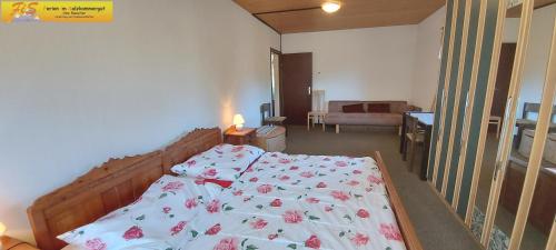 1 dormitorio con 1 cama grande con flores rosas en Apartment Adam Tauplitz by FiS - Fun in Styria, en Tauplitz