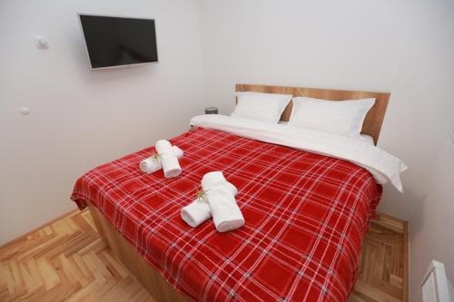 a bedroom with a bed with two towels on it at Apartman Una in Pale