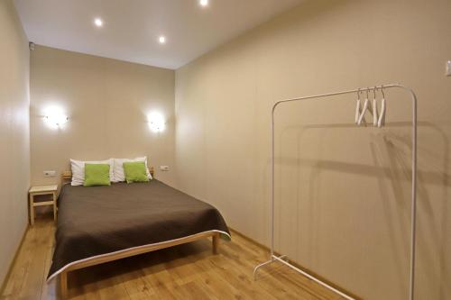 um quarto com uma cama com almofadas verdes em Ural Apartment em Chelyabinsk