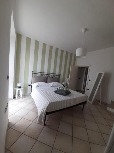 una camera con un letto a righe di B&B InCentro a Ripatransone