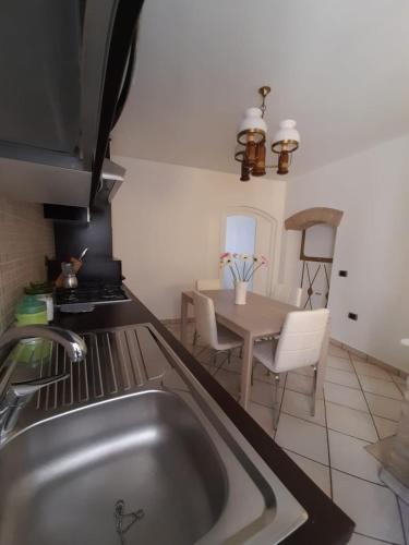 a kitchen with a sink and a table with chairs at B&B InCentro in Ripatransone