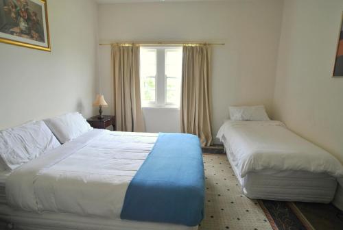 a bedroom with two beds and a window at Cooma Cottage in Cooma