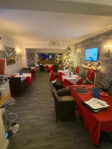 a dining room with tables and chairs and christmas decorations at Mariners Hotel in Seaton