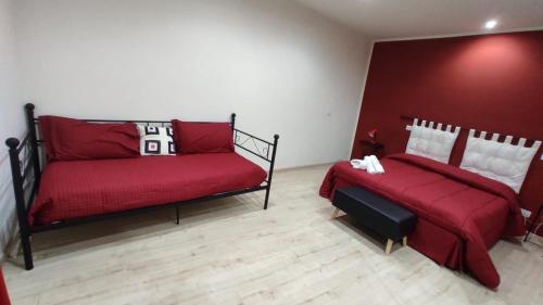 een slaapkamer met 2 bedden en een rode muur bij Casa Tintilia in Isernia