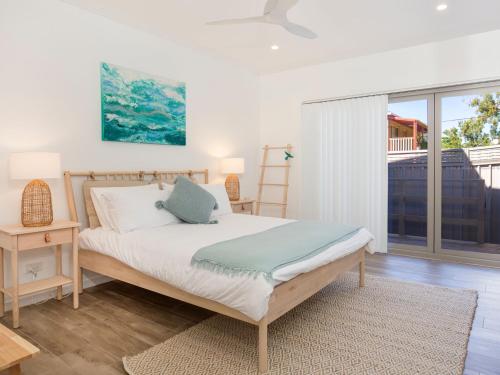 a bedroom with a bed and a large window at Salty Shores Jervis Bay I 3 Mins to Beach in Callala Beach