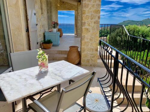 a table and chairs on a balcony with a view of the ocean at Villa Grand Baie in Agay - Saint Raphael