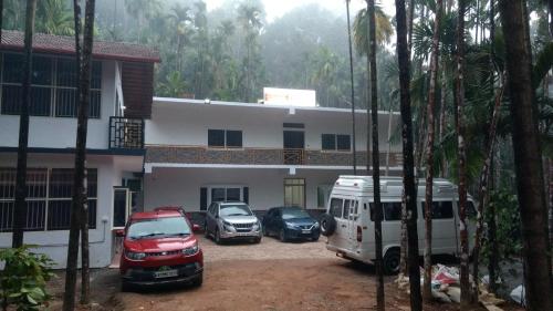 a group of cars parked in front of a building at Hosamane Farm Inn in Sringeri