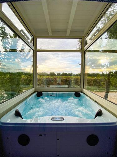 a large bath tub in a room with two windows at Tenuta Vigna del Noce in Corato