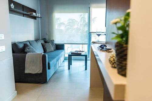 Hauzify I Apartaments Grup Claustre في توريديمبارا: غرفة معيشة مع أريكة زرقاء وطاولة