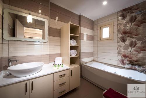 a bathroom with a sink and a bath tub and a sinkonnaissance at Pilot's Villas Luxury Suites in Hersonissos