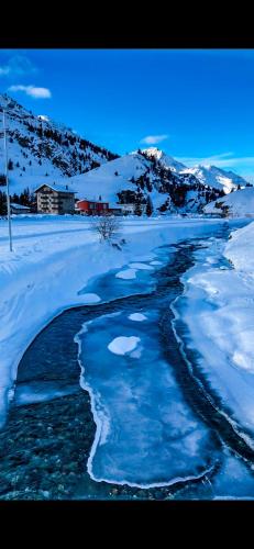 a stream of water with snow on the ground at Ferienwohnung in den Bergen mit grosser Terrasse in Bivio