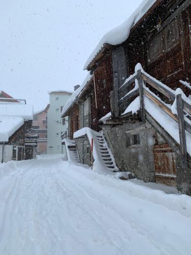 a snow covered building with a snow covered staircase at Ferienwohnung in den Bergen mit grosser Terrasse in Bivio