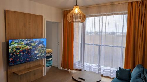 a living room with a large window and a large aquarium at APARTAMENT BLUE , Marynarska 8 , Sarbinowo in Sarbinowo