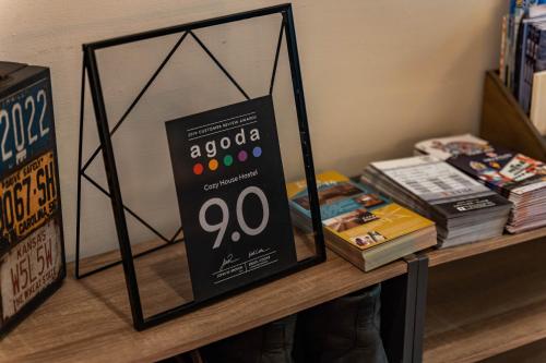 a sign on top of a shelf with books at Cozy House Hostel in Hualien City