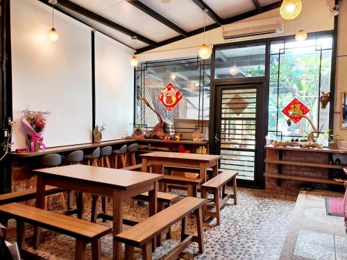 a restaurant with wooden tables and benches in a room at Stone Home Bed and Breakfast in Taitung City