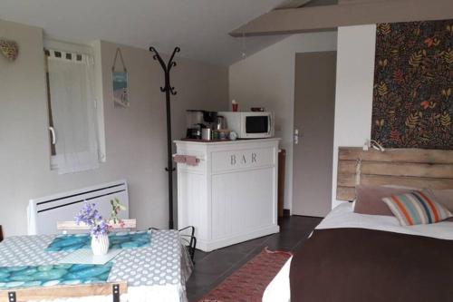 une chambre avec deux lits et une cuisine avec un four micro-ondes dans l'établissement studio entre Mt-St-Michel et St- Malo, à Dol-de-Bretagne