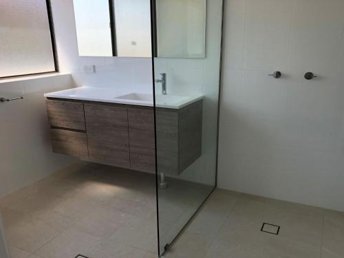 a bathroom with a sink and a glass shower at Bangalee 3 Fantastic Waterfront Unit with Pool WI FI and Chromecast in Soldiers Point
