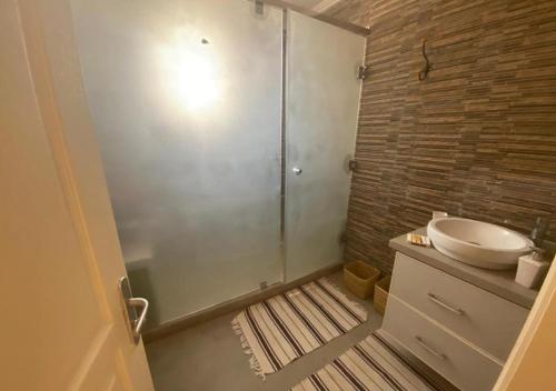 uma casa de banho com um lavatório e uma cabina de duche em vidro. em Villa nahellan em Marrakech