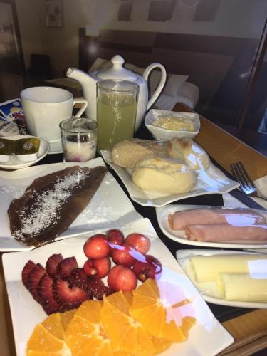 a table topped with plates of food and fruit at Hotel Boutique Reyall in Santiago