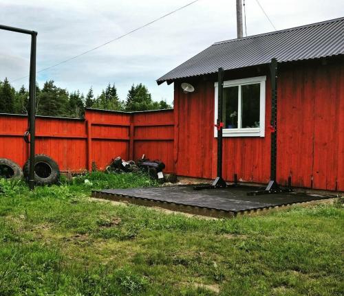 a red house with a red fence at Lilla lägenheten Västra Karstorp in Aneby