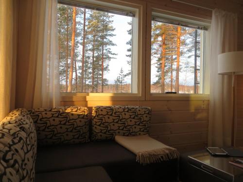 a living room with a couch and two windows at Ankkuri Raijan Aitta in Mikkeli