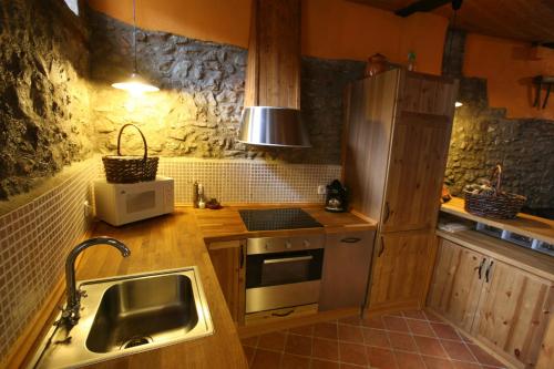 Cal Ferrer Nou في Alpens: مطبخ مع مغسلة وموقد فرن علوي