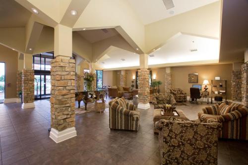a lobby with couches and chairs and a stone fireplace at Holiday Inn St. Paul Northeast - Lake Elmo, an IHG Hotel in Lake Elmo