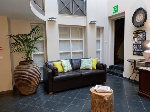 un salon avec un canapé et une plante dans l'établissement Hotel Côté Cour, à Durbuy