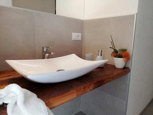 La salle de bains est pourvue d'un lavabo blanc sur un comptoir en bois. dans l'établissement Casa Lassù, à Carano