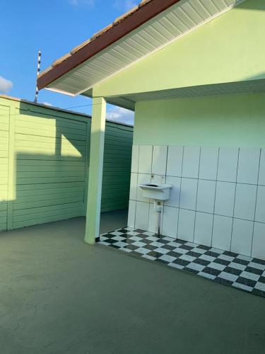 a garage with a toilet on a checkered floor at Casa, 1 quadra da praia. in Ilha Comprida