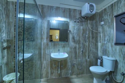 a bathroom with a toilet and a sink and a shower at Harmony House - A Boutique Hotel in Guwahati