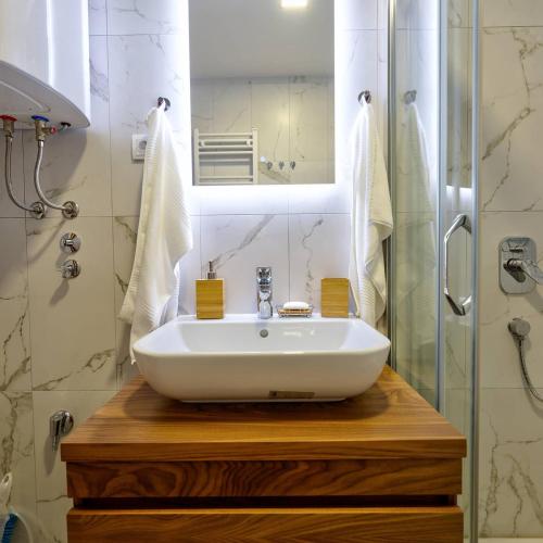 a bathroom with a white sink and a shower at Zlatibor apartman Asteri in Zlatibor