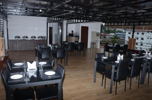 a dining room with black tables and black chairs at Hotel Seagull in Aberdeen