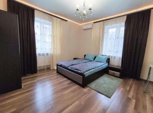 een slaapkamer met een bed en 2 grote ramen bij Люкс апартаменти двокімнатні в центрі міста на Ерусалимці поруч з фонтаном Рошен in Vinnytsya