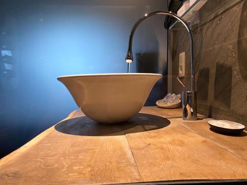 a bowl sitting on top of a wooden table at Hôtel WELLNESS EAU DE ROCHE Durbuy in Durbuy