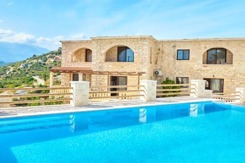 una villa con piscina frente a una casa en ANEMOS residence, en Exopoli