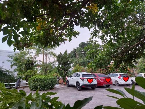 drie auto's geparkeerd op een parkeerplaats met harten erop bij Scenic Riverside Resort in Kamphaeng Phet